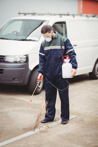 Handyman with insecticide standing in front of his van