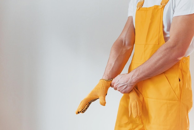 Handyman in yellow uniform preparing for work indoors House renovation conception