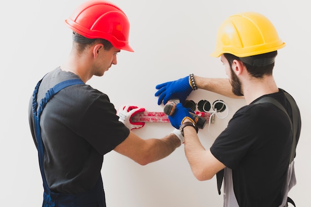 Photo handymen installing plug with level