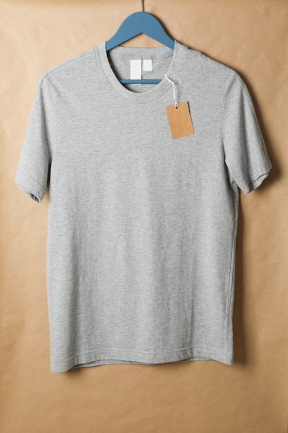 Hanger met blanco grijs t-shirt en label op karton