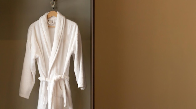 Hanger met schone witte badjas in hotelgarderobe