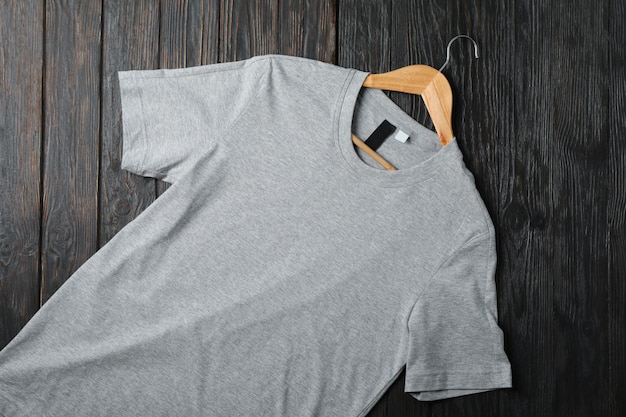 Hanger with blank gray t-shirt on wooden