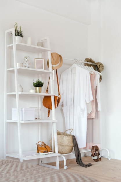 Hanger with clothes in trendy pastel colour on a rack with accessories 