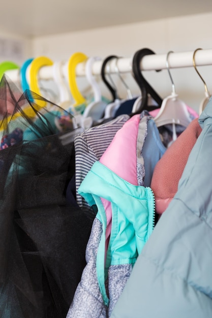 Hangers met verschillende kleding in garderobekast Kledingopslag