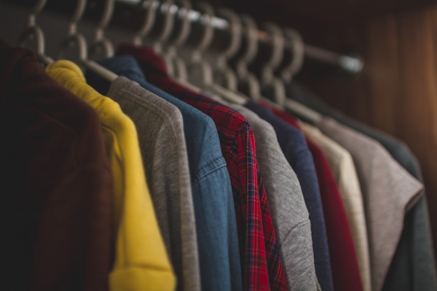 Hangers met verschillende vrijetijdskleding in de kast van de huisgarderobe