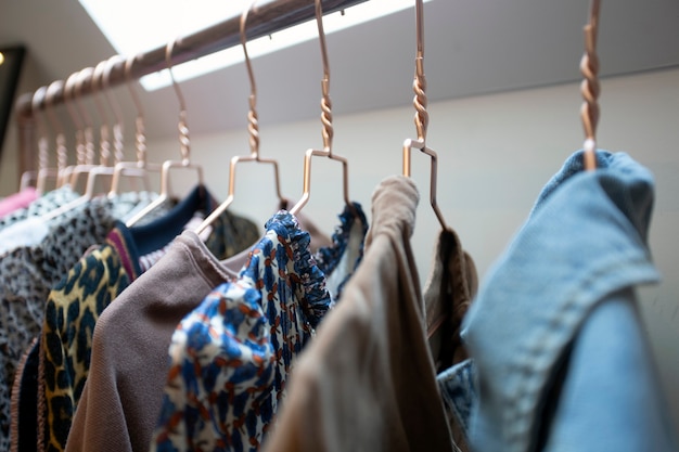 Hangers op rek met kleurrijke stijlvolle mode kleding in moderne kamer. huisinterieur, mode en opbergconcept