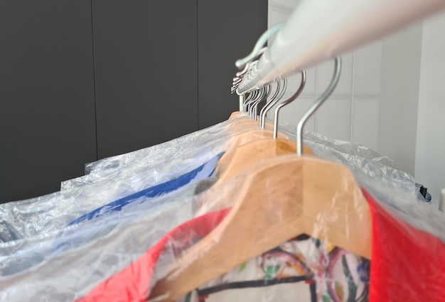 Hangers with clean clothes in laundry room