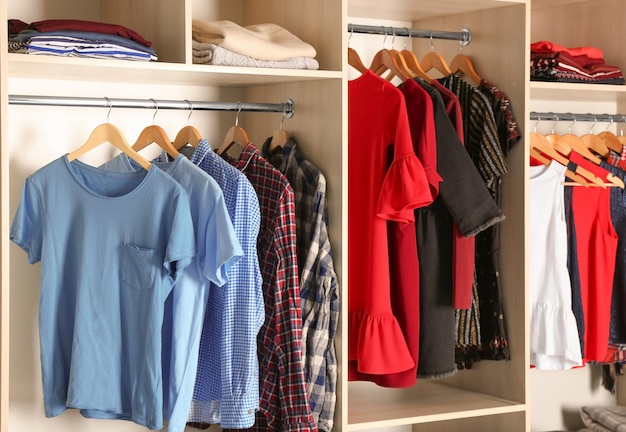 Hangers with different clothes in wardrobe closet