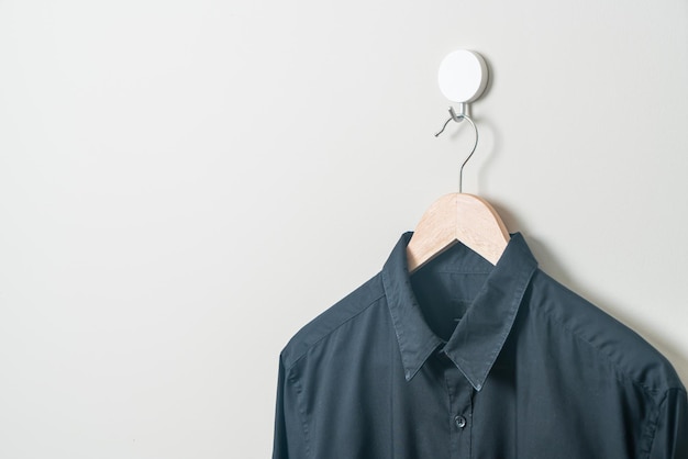 hanging black shirt with wood hanger on wall