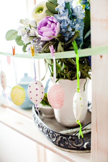 Photo hanging eggs on the ribbon - easter decortaions on the shelf indoor