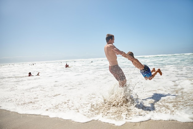 Hanging out at the beach Shot of a father and his son having fun at the beach