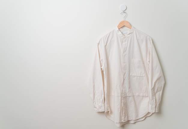 Hanging shirt with wood hanger on wall