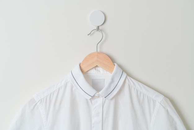 Hanging shirt with wood hanger on wall