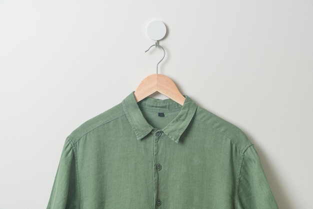 Photo hanging shirt with wood hanger on wall