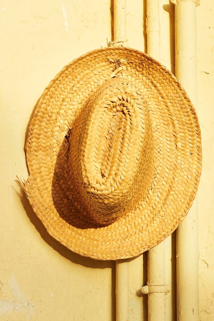 hanging Wicker straw hats on wall Sun light and shadows