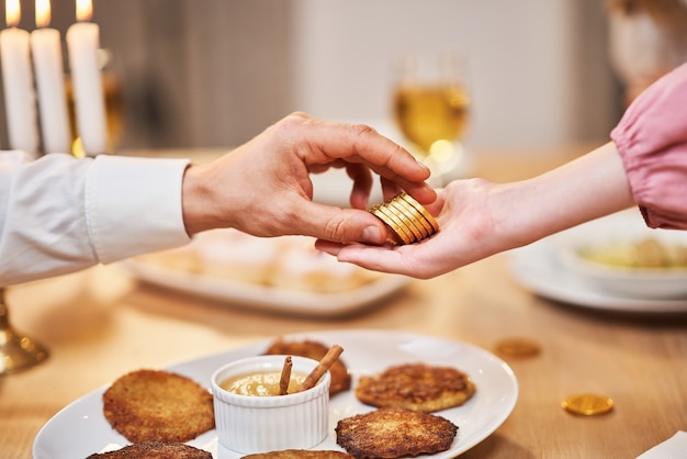 Cena di hanukkah. famiglia riunita intorno alla tavola con i piatti della tradizione