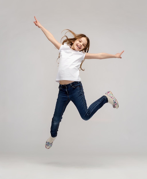 Photo happiness, activity and child concept - smiling little girl jumping