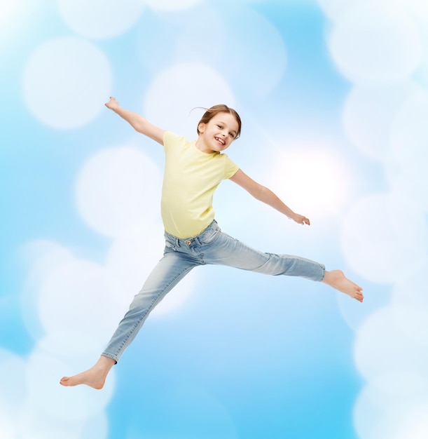 счастье, активность и детская концепция - улыбающаяся маленькая девочка прыгает