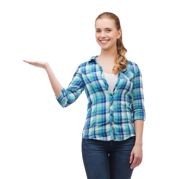 happiness, advertising and people concept - smiling young woman holding something on palm of her hand