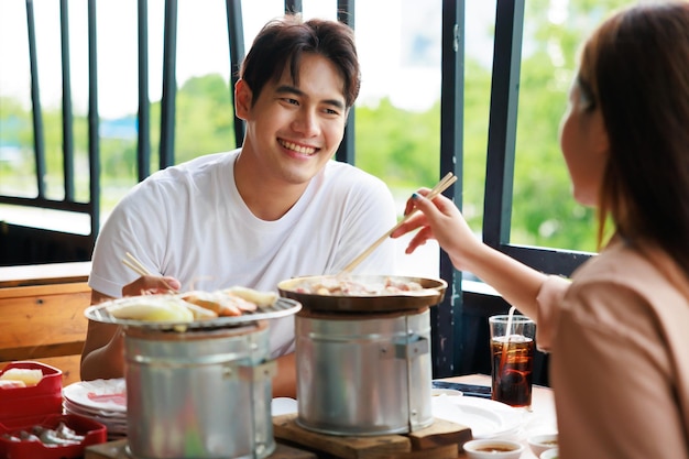 Felicità uomo asiatico che mangia pranzo con la sua ragazza per l'anniversario incontri al ristorante alla griglia