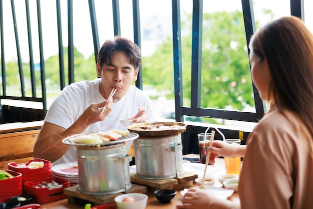 구운 레스토랑에서 기념일 데이트에 여자 친구와 점심을 먹는 행복 아시아 남자