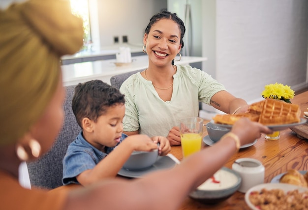 幸せな朝食の食べ物と家族が食事ワッフルを食べたり、一緒に朝の時間を楽しんだり、自宅でのランチやダイニングルームでのブランチを楽しんだり、愛の人が気を配ったり、リラックスしたり、お腹を空かした人たちを軽食を与えたりする子供や両親