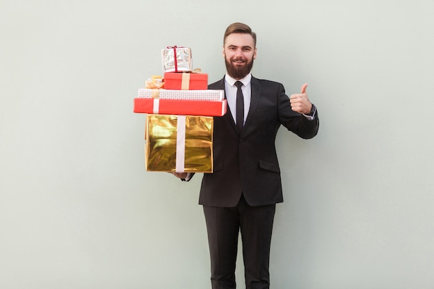 Happiness businessman toothy smile holding box and thumbs up