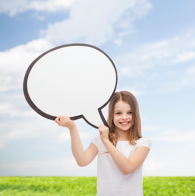 happiness, child, conversation and people concept - smiling little girl with blank text bubble