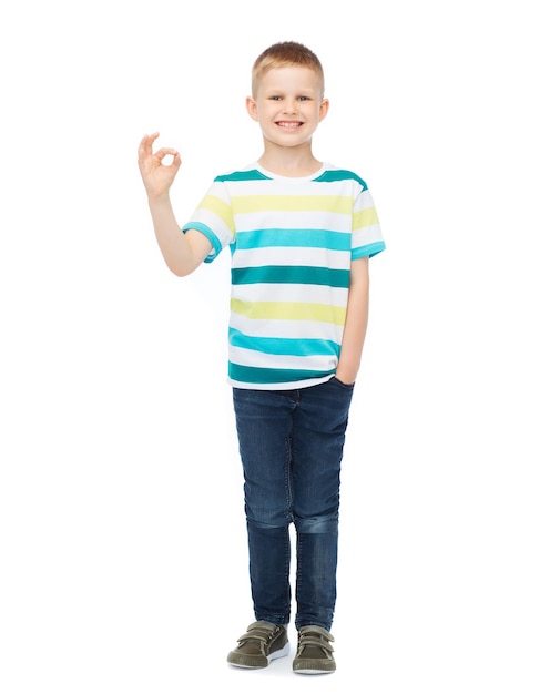 Photo happiness, childhood, accomplishment and people concept - smiling little boy in casual clothes showing ok gesture