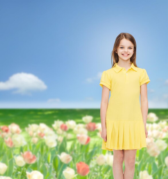 happiness, childhood and people concept - smiling little girl in yellow dress