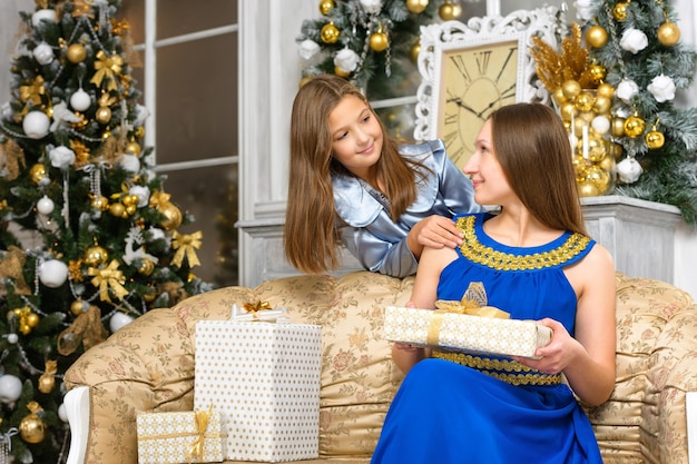 Foto concetto di famiglia di natale di felicità - madre con scatole regalo e figlia