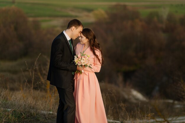 屋外を歩く結婚式の日の幸せカップル。