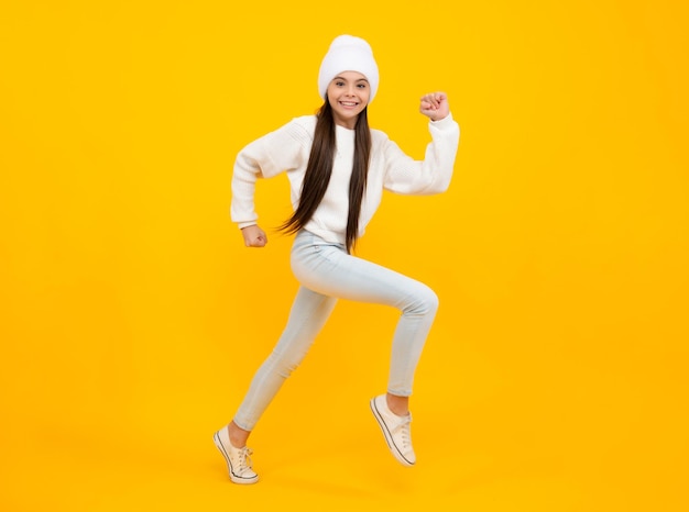 Happiness freedom motion and child Young teenager girl jumping over yellow background funny jump