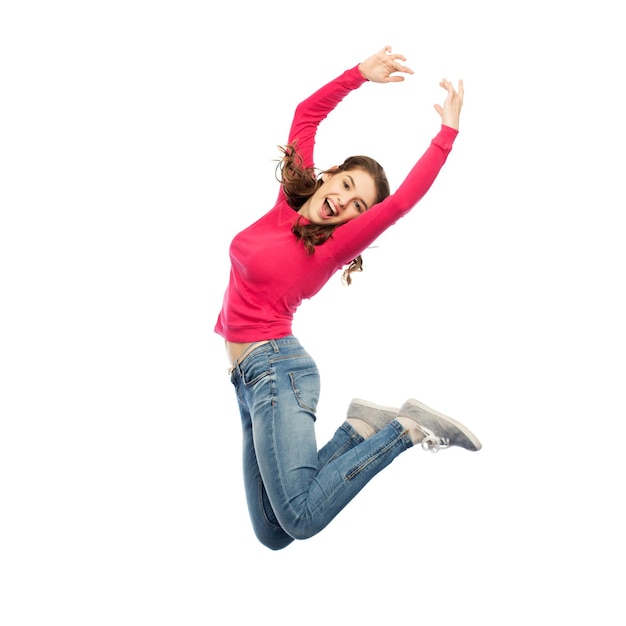 happiness, freedom, motion and people concept - happy young woman jumping or dancing in air over white background