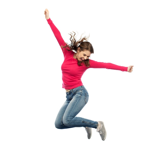 Photo happiness, freedom, motion and people concept - smiling young woman jumping in air over white background