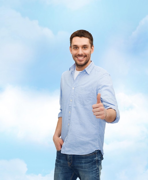 happiness, gesture and people concept - smiling man showing thumbs up