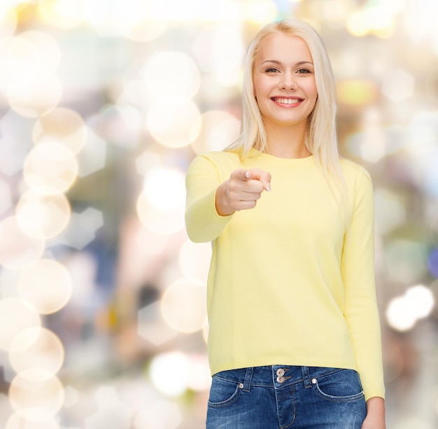 happiness, gesture and people concept - smiling woman pointing finger at you