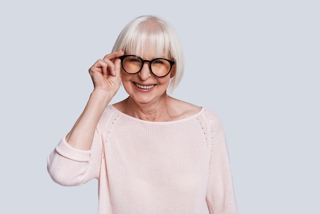 Happiness has no age. Beautiful senior woman adjusting eyewear and smiling 