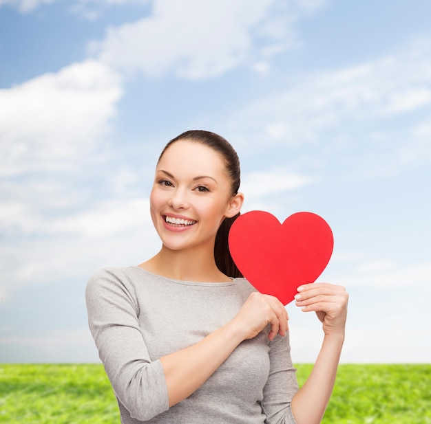 happiness, love and health concept - smiling asian woman with red heart