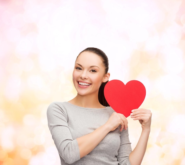 happiness, love and health concept - smiling asian woman with red heart