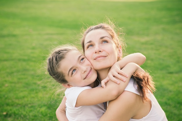 Happiness - mother hugging her child during the walk in the park looking up.