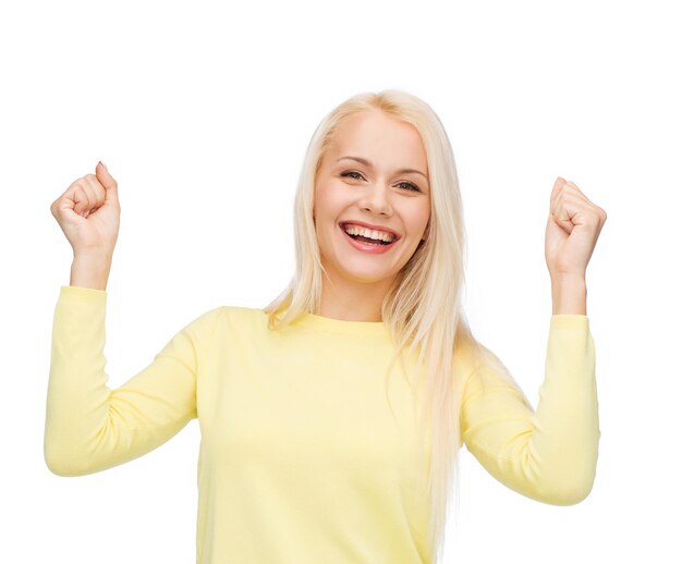 happiness and people concept - laughing young woman with hands up celebrating victory