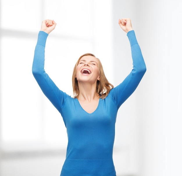 happiness and people concept - laughing young woman with hands up and closed eyes