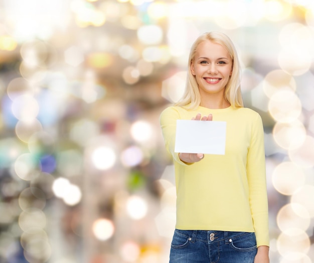 happiness and people concept - smiling young woman in casual clothes with white blank business or name card