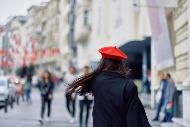 Happiness woman jumps and runs follow me walks walks in the city against the backdrop of office buildings stylish fashionable vintage clothes and makeup spring walk travel