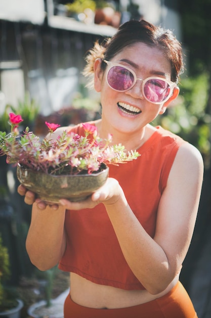 スベリヒユの花の植木鉢を育てる幸せな女性