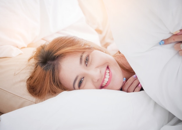 Photo happiness woman smiling on morning on her bed.