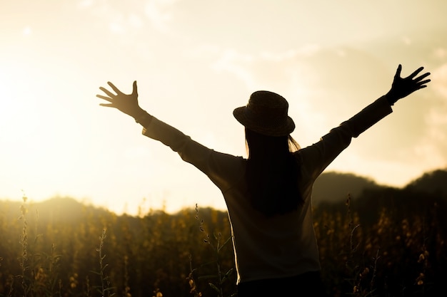 La felicità donna rimane all'aperto in giardino di fiori sotto la luce del sole