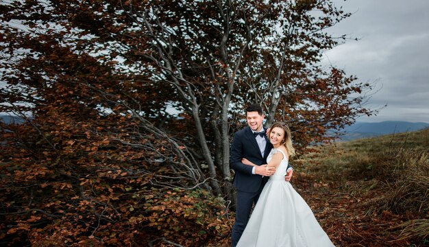 The happinest brides embracing near trees