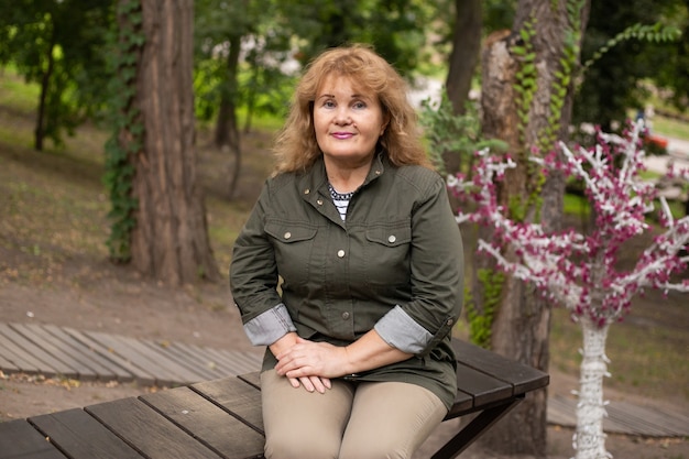 Photo happy active retired senior woman in autumn park on nature